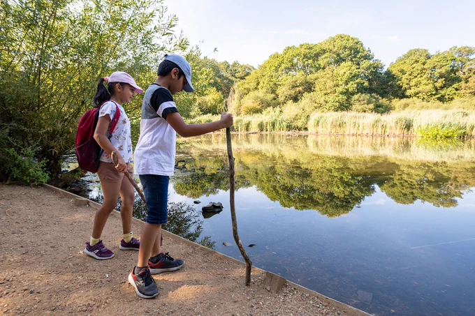 Two children look over a lake