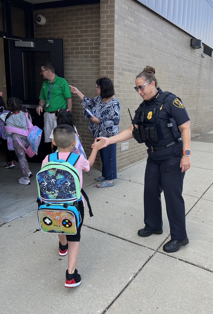 sdu46's tweet photo. A slightly different morning for Elgin Police Dept. Chief of Police Ana Lalley and the team! They welcomed students on their first day back to school. Their high fives wishing students & staff a successful & safe school year ahead was a great start for all. #U46FirstDay2023 https://t.co/8B85mWqJKT