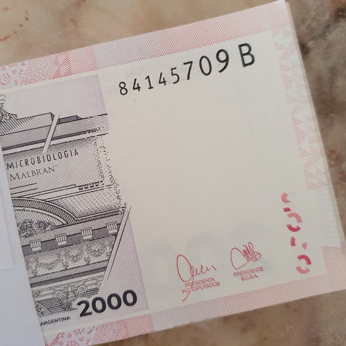 This $2k pesos banknote has been in circulation for 85 days. 

It already reached series B. In other words, they have already printed $168,291,418,000 pesos only for this series. 

If you add series A: $368,291,418,000 pesos to get to the number in the photo.

Total destruction.