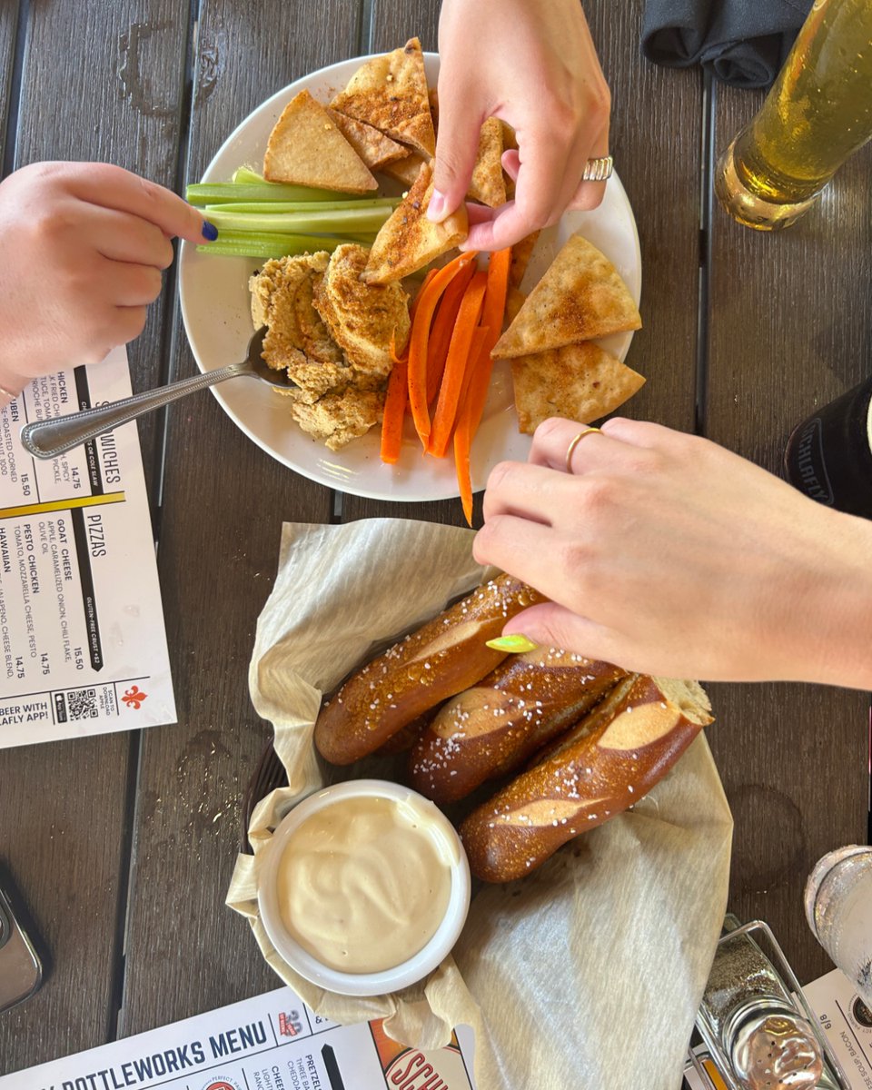 Our two fan-favorite appetizers at Bottleworks... Bavarian pretzel sticks with white cheddar sauce & hummus with roasted garlic, lemon, sesame, fresh veggies, and crispy pita What are your favorite Schlafly eats? Comment down below. ⬇️