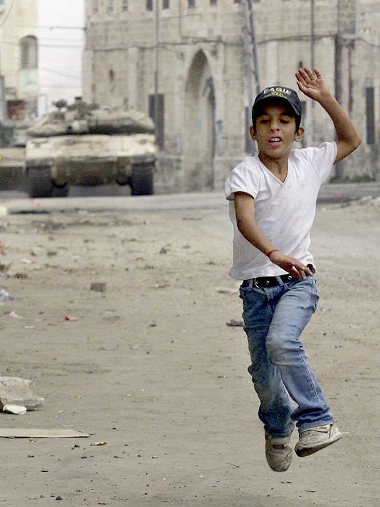 PalestinianPic's tweet photo. طفل فلسطيني يركض أمام دبابات الاحتلال التي تجتاح مدينة جنين. 

الطفل الظاهر في الصورة هو المطارد مصطفى الكستوني "أبو علي"، الذي ارتقى في اشتباك مسلح مع جيش الاحتلال في مخيم جنين صباح اليوم، بعد 20 عامًا على التقاط هذه الصورة. 

📷 SAIF DAHLAH
🗓️ 2003 https://t.co/08DuseOeqo