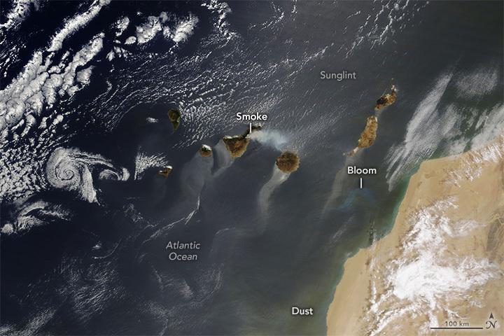 NASAEarth's tweet photo. Wildfire smoke, cloud vortices, airborne Saharan dust, and an algae bloom are all visible in this satellite image of the Canary Islands off the coast of Africa on August 16, 2023. https://t.co/jfxEwVz9IX https://t.co/te3nbf6qUI