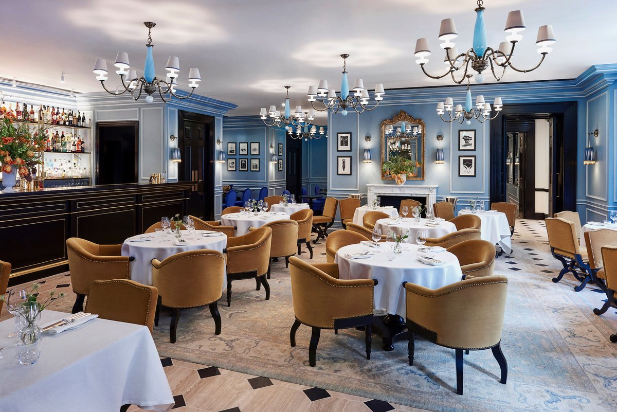Our original sketch for the restaurant of <a href="/the22/">The 22</a>.london. Swipe to see the result. We used four shades of blue on the walls to highlight aspects the panelling. I designed the bespoke chandeliers in cadets of handblown blue glass and brass.
