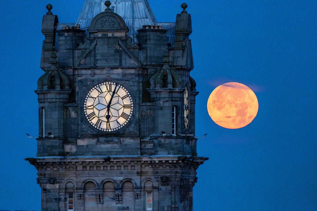 The super blue moon sets behind the Balmoral Clock in Edinburgh. The blue moon refers to the second full moon in one calendar month which occurs very rarely :: #moon #bluemoon #supermoon #balmoralclock #edinburgh #scotland