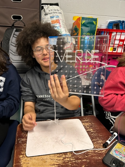 JaneWHerndon's tweet photo. A fun and creative way to review vocabulary words: Geoboarding! @SenoraGante calls out words, &amp; students demonstrate their understanding of Spanish by weaving shapes, words, patterns, and pictures. #GoBJHS https://t.co/hxQV4IB7GE