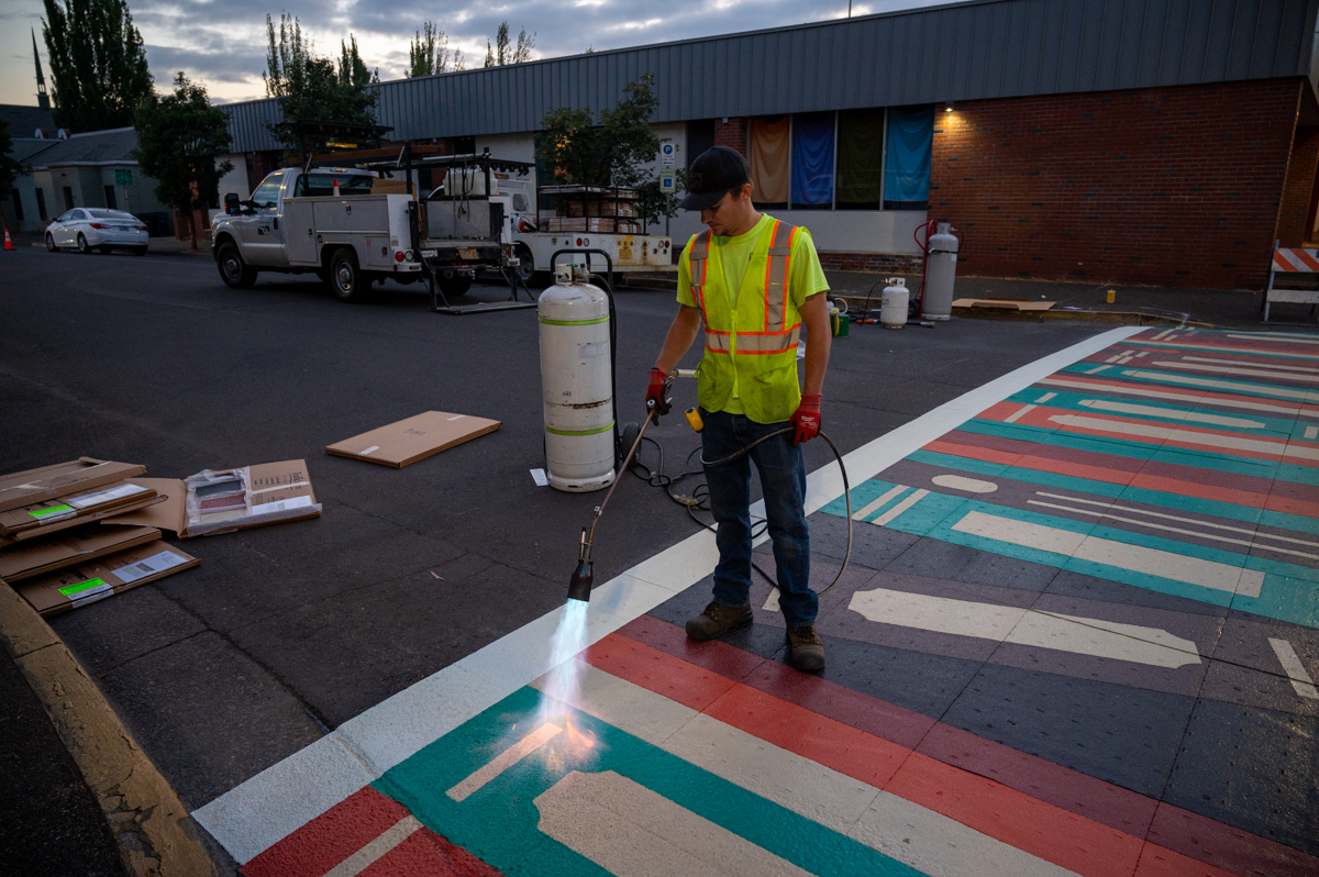 cityspfldoregon's tweet photo. New crosswalk art was installed at 4th and 5th St. at Main St. and features artwork of books on a shelf designed by Joely Ann Davis and a yellow brick road designed by Tara Kemp. The project from the Springfield Economic Development Agency adds to Downtown's inviting atmosphere. https://t.co/XjUxuOx0Np