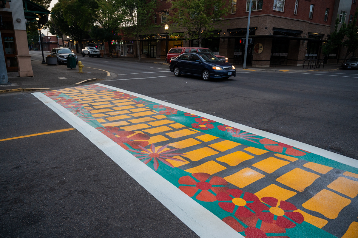 cityspfldoregon's tweet photo. New crosswalk art was installed at 4th and 5th St. at Main St. and features artwork of books on a shelf designed by Joely Ann Davis and a yellow brick road designed by Tara Kemp. The project from the Springfield Economic Development Agency adds to Downtown's inviting atmosphere. https://t.co/XjUxuOx0Np