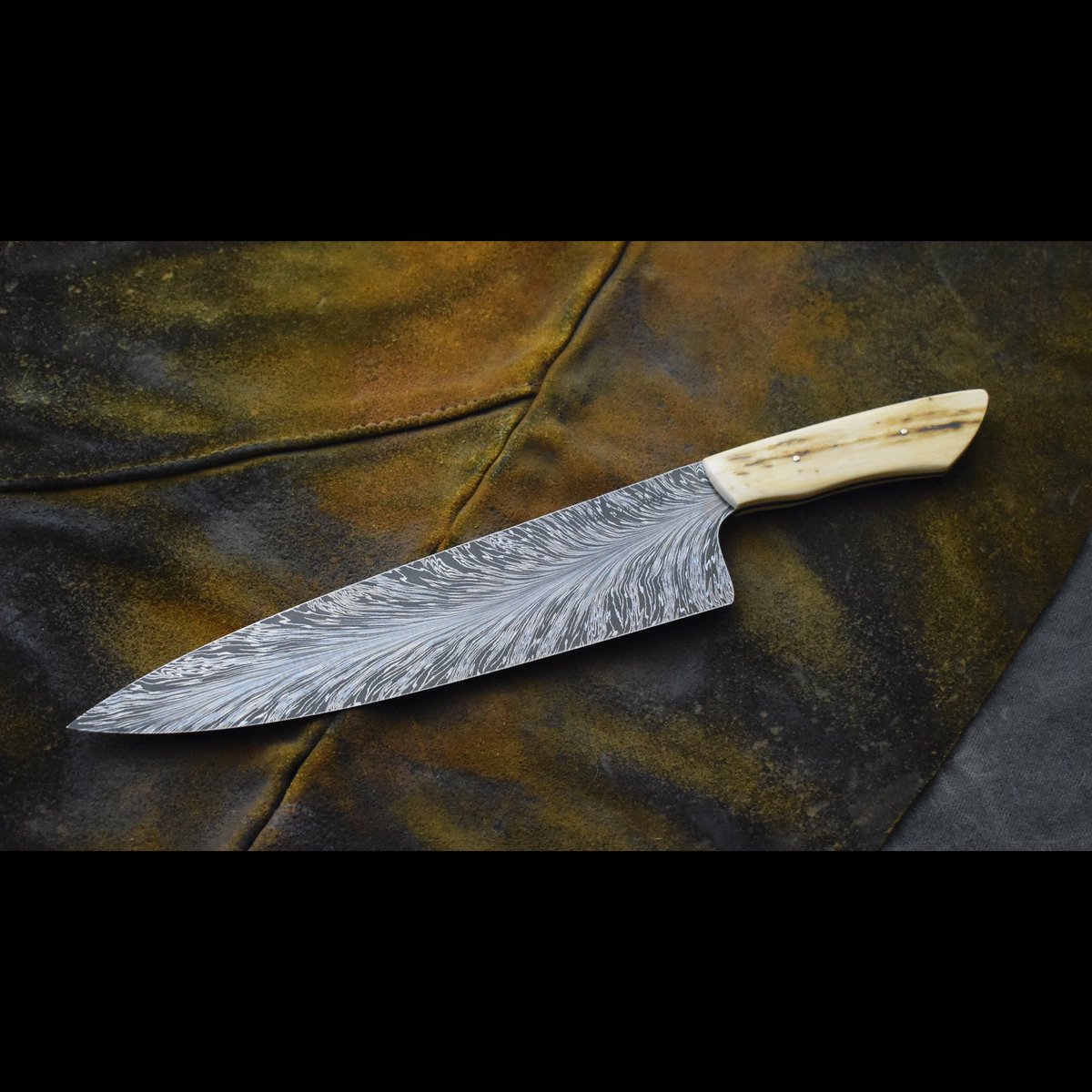 An old knife I made with mammoth ivory scales and peened pins. I love the feather pattern on this one.