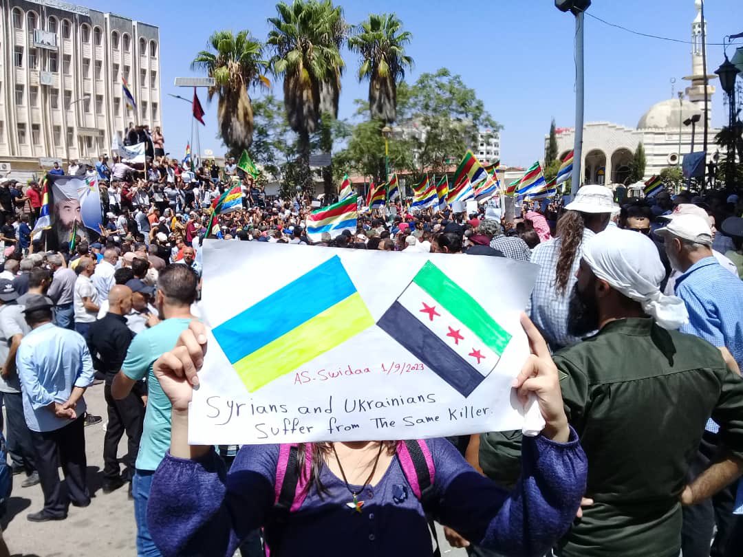 This picture is of my brave friend from inside the protests in Sweida today. she reminds the world that Syrians and Ukrainians are suffering from the same criminals. The Syrian people are truly resilient despite all the suffering, and we stand with Ukraine, continuing to send…