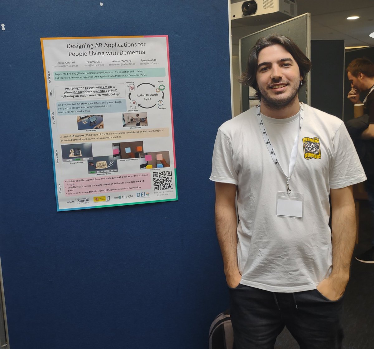 alreylz's tweet photo. This is me during today's poster session at #Interact2023 presenting my colleagues' work "Designing AR Applications for People Living with Dementia"
Two AR game prototypes (HMD vs handheld) were designed to explore the potential of #AR in cognitive stimulation in this context. https://t.co/DjjACmSL8T