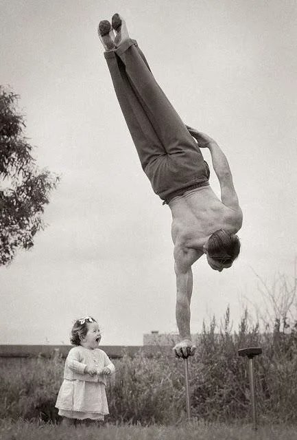 Dad showing off his skill to the surprise of his little daughter in Melbourne, Australia, 1940's