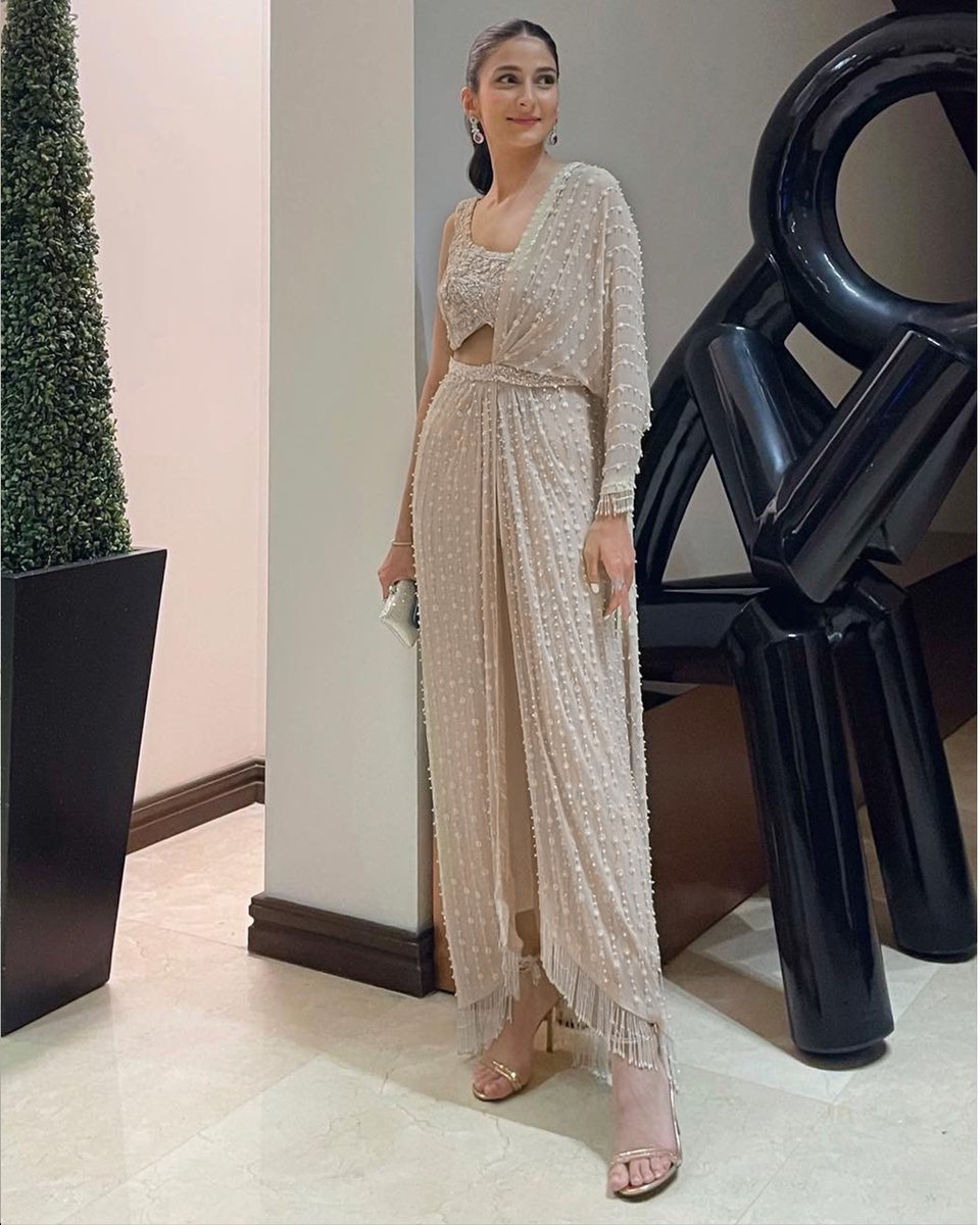 Alishay Adnan, Pakistan's cherished style icon, emanates resplendent charm draped in an ethereal Élan Couture look. Adorned with intricate beadwork and glistening pearls, the celestial ivory hues transform her into a vision of elegance, epitomizing flawlessness in every facet.