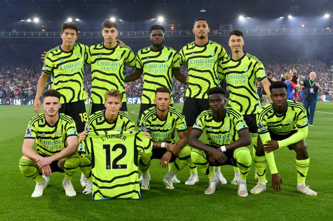 The Arsenal players pre game holding up Jurrien Timber's shirt.