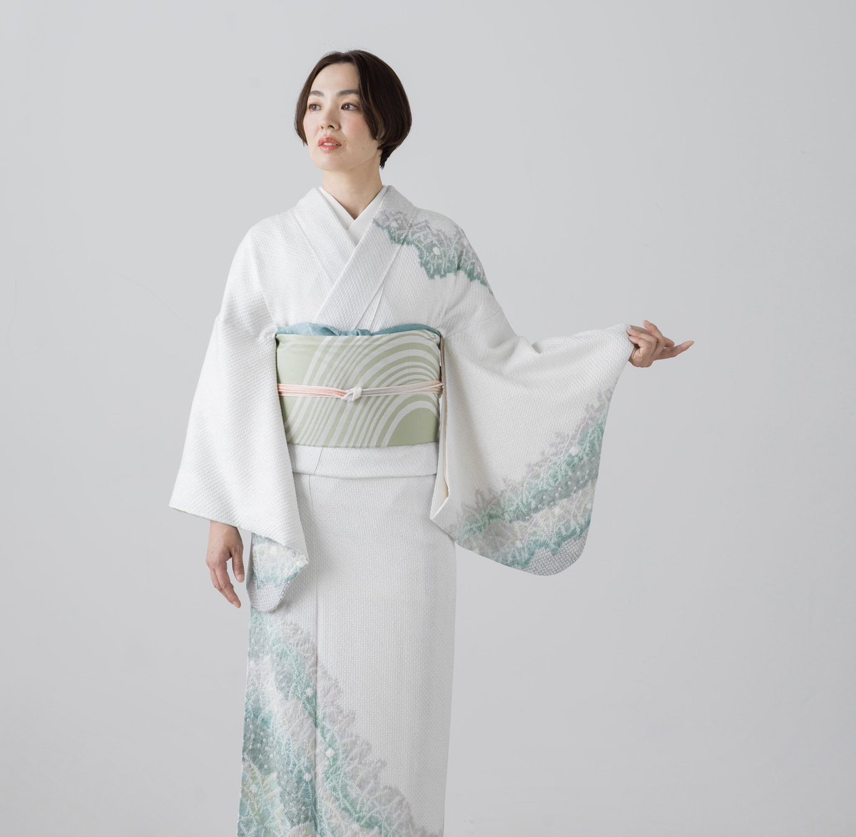 淡い色彩とすっきりとした柄行が人気の訪問着「夢かさね」。金糸銀糸の袋帯を合わせる正統派フォーマルだけではなく、少しカジュアルダウンしたい時にも使える便利なきもの。写真はグリーンのワントーンコーデに帯締めを淡いピンクにして、入学式に付き添う母を意識したスタイル。