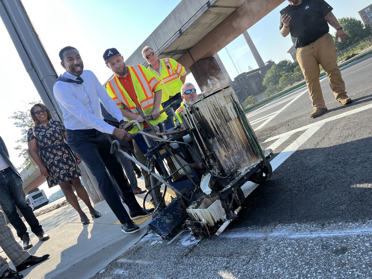 Mayor Andre Dickens doing some final striping work to celebrate completion of DeKalb Avenue