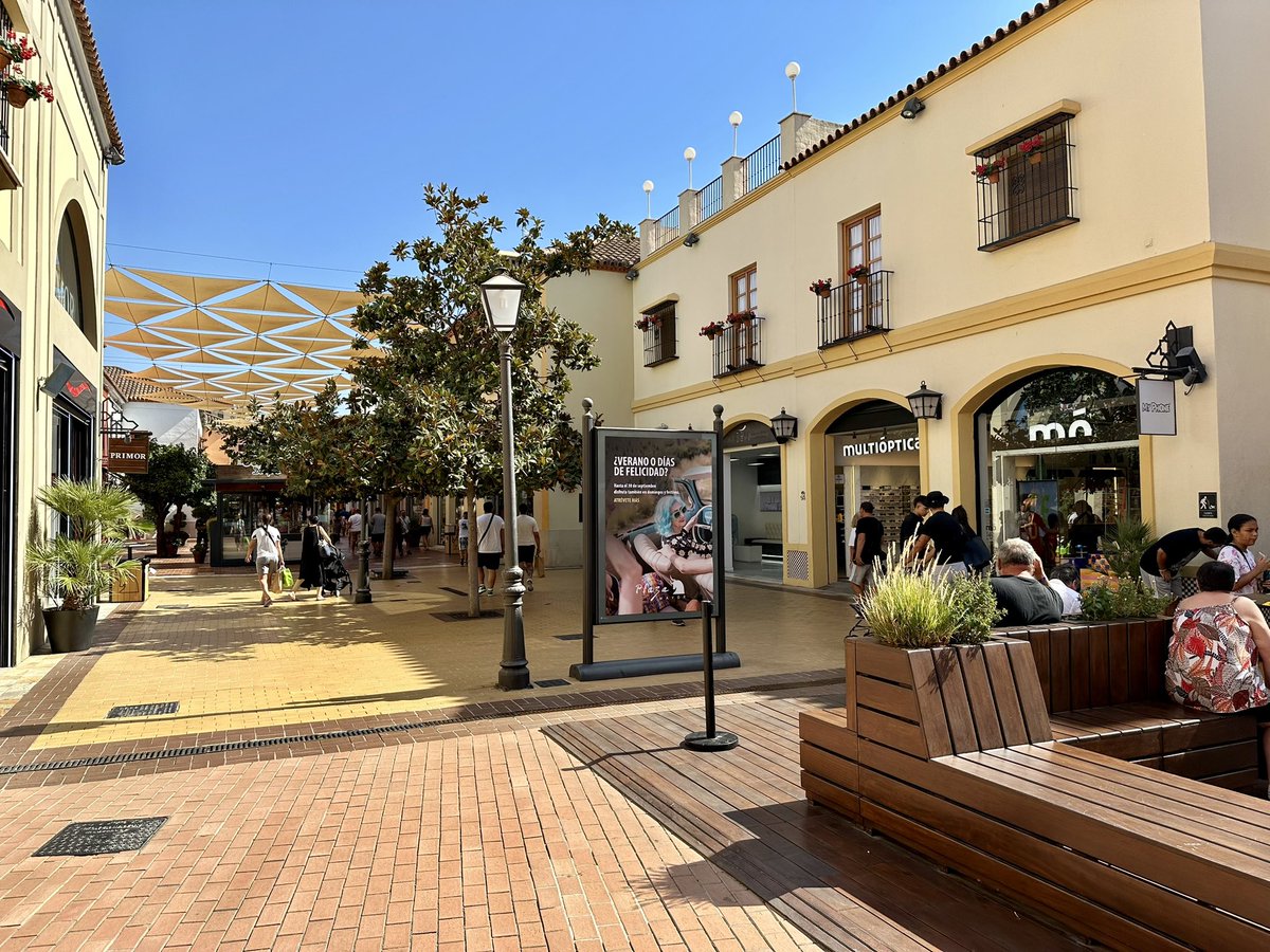 giraldeo's tweet photo. ¿Cómo debe ser una ciudad que favorezca al comercio? Mirad estas calles: ejes peatonales clave, árboles de porte y sombra, espacios de ocio, mobiliario urbano accesible, una proporción aceptable de espacio libre y terrazas, elementos de sombra adicionales como toldos, áreas estanciales gratuitas…

Pero es todo de mentira, no es un pueblo real. Es el centro comercial Plaza Mayor, en Málaga. Muy similar a otros como Las Rozas Village en Madrid. Es llamativo cómo en un complejo comercial privado se busca lo que en muchos lugares reales se critica como perjudicial al comercio. ¿Que peatonalizar una calle es su ruina comercial? Jamás hemos visto eso.

Salvando las distancias (por supuesto, no somos ingenuos), son muy curiosas este tipo de experiencias. Se construye una ciudad de cartón piedra para imitar ¿una ciudad ideal? Parece que más o menos se tiene claro cómo debe ser.
