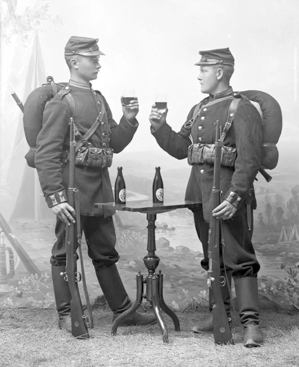 In this early 1900s photograph, two unidentified soldiers from the Gotland Infantry Regiment (I 27) are captured in their full military attire, holding beer glasses. The photo was taken at Nils Johan August Lagergren's photography studio in Visby, Gotland, Sweden.

Lagergren's