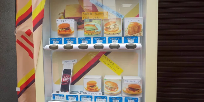 ヒゲのおじさんのじゃないハンバーガーの自販機を発見。筐体にレンジ機能はないので持ち帰って自分で暖めるスタイルだけどドクペ買えるのがアツい! 
