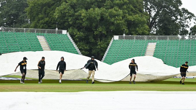 Groundstaff pull on the covers at The Village, Malahide