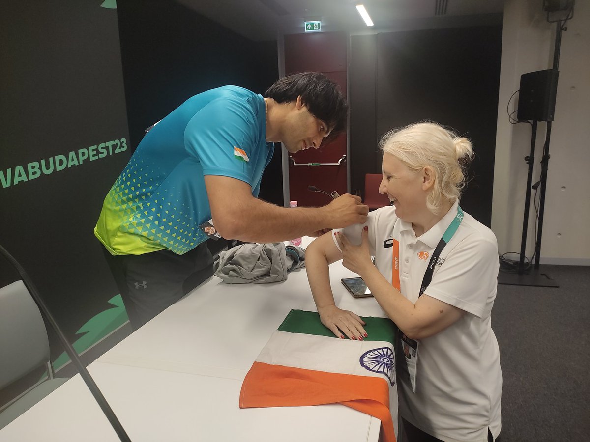 jon_selvaraj's tweet photo. A very sweet Hungarian lady (who spoke excellent Hindi btw) wanted a Neeraj Chopra autograph. Neeraj said sure but then realised she meant on the 🇮🇳 flag. 'Waha nahi sign kar sakta' Neeraj tells her. Eventually he signed her shirt sleeve. She was pretty happy all the same. https://t.co/VhZ34J8qH5