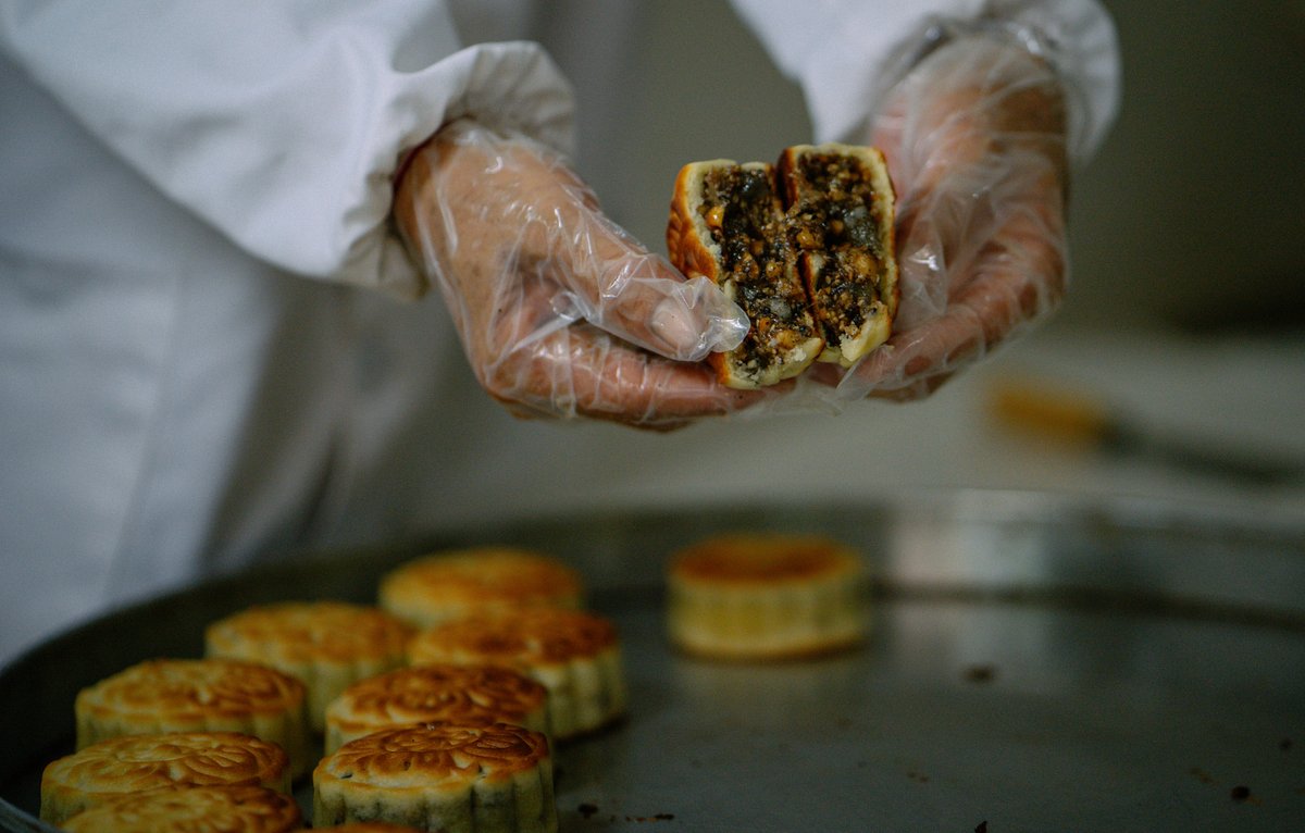 ChinaDaily's tweet image. Mixing flour with walnuts, raisins, peanuts, and more, then into the oven it goes! Experience the magic of "firewood mooncakes", where wood fire roasts the top and charcoal works below. #food #mooncake