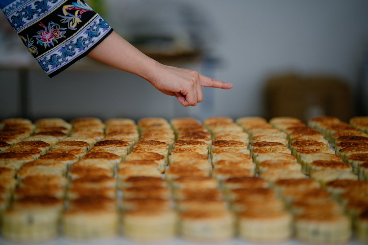 ChinaDaily's tweet image. Mixing flour with walnuts, raisins, peanuts, and more, then into the oven it goes! Experience the magic of "firewood mooncakes", where wood fire roasts the top and charcoal works below. #food #mooncake