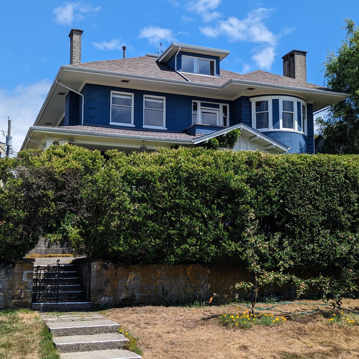 Heritage spotlight: This grand Edwardian home, built in 1911, exhibits asymmetrical massing and incorporates a fusion of Craftsman-inspired elements within its verandah. It stands out due to its unique utilization of concrete blocks. #iloveheritage #heritagehouse