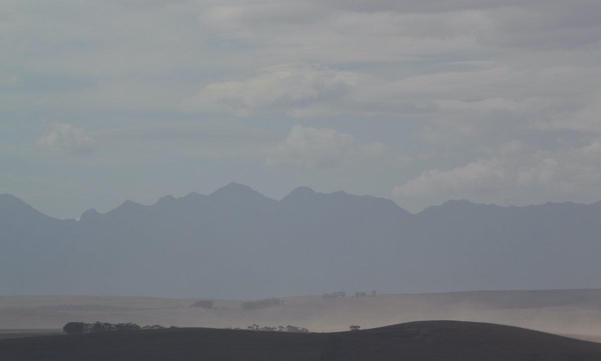 forgottenfield's tweet image. A haze of dust in the distance overlooked by the majestic Riviersonderend ('river without end') mountain range, photographed in mid-autumn, 18 April 2018, Overberg region, Western Cape Province, South Africa.