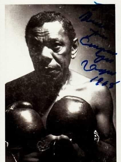 A signed photo of 'Champion' Jack Dupree wearing boxing gloves. The photo was taken in 1968, decades after Dupree's boxing career had ended. From 1940 onward, he spent life as a highly sought-after bluesman. Can you name other famous blues playing pugilists? Willie Dixon was one.