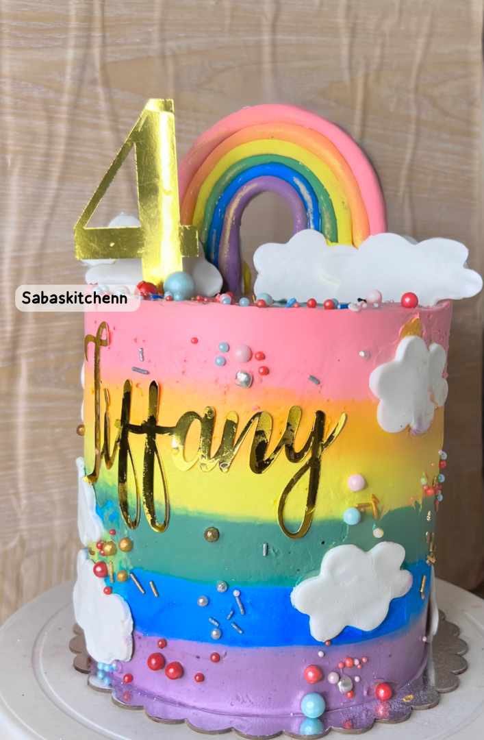 3 layered chocolate cake  with rainbow frosting + fondant rainbow and clouds $
& personlized name and number topper