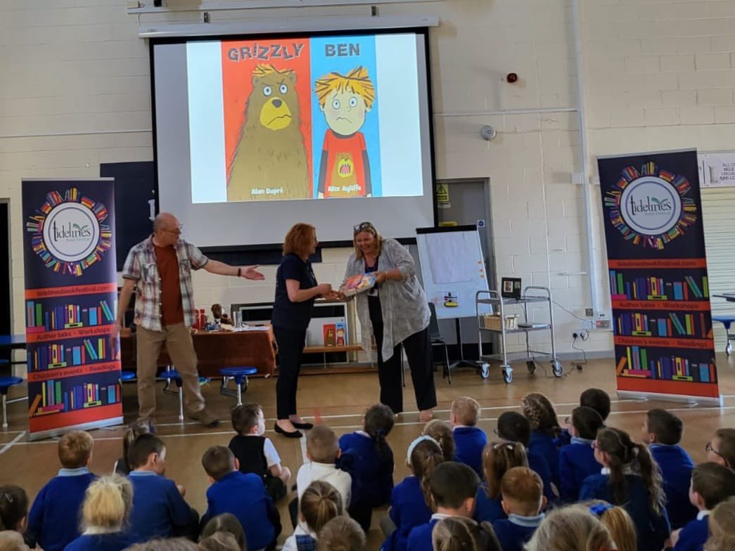 TidelinesFest's tweet photo. Today we took author @AlanDapre to the fabulous Ardeer Primary for the 3rd of our 10 school visits and left them some copies of Grizzly Ben for the school, handed over by volunteer &amp; hard working Tidelines Secretary Julie. Thank you to Specsavers Irvine &amp; @CunninghameHA 📚❤️ https://t.co/Qb5BEmwJgu