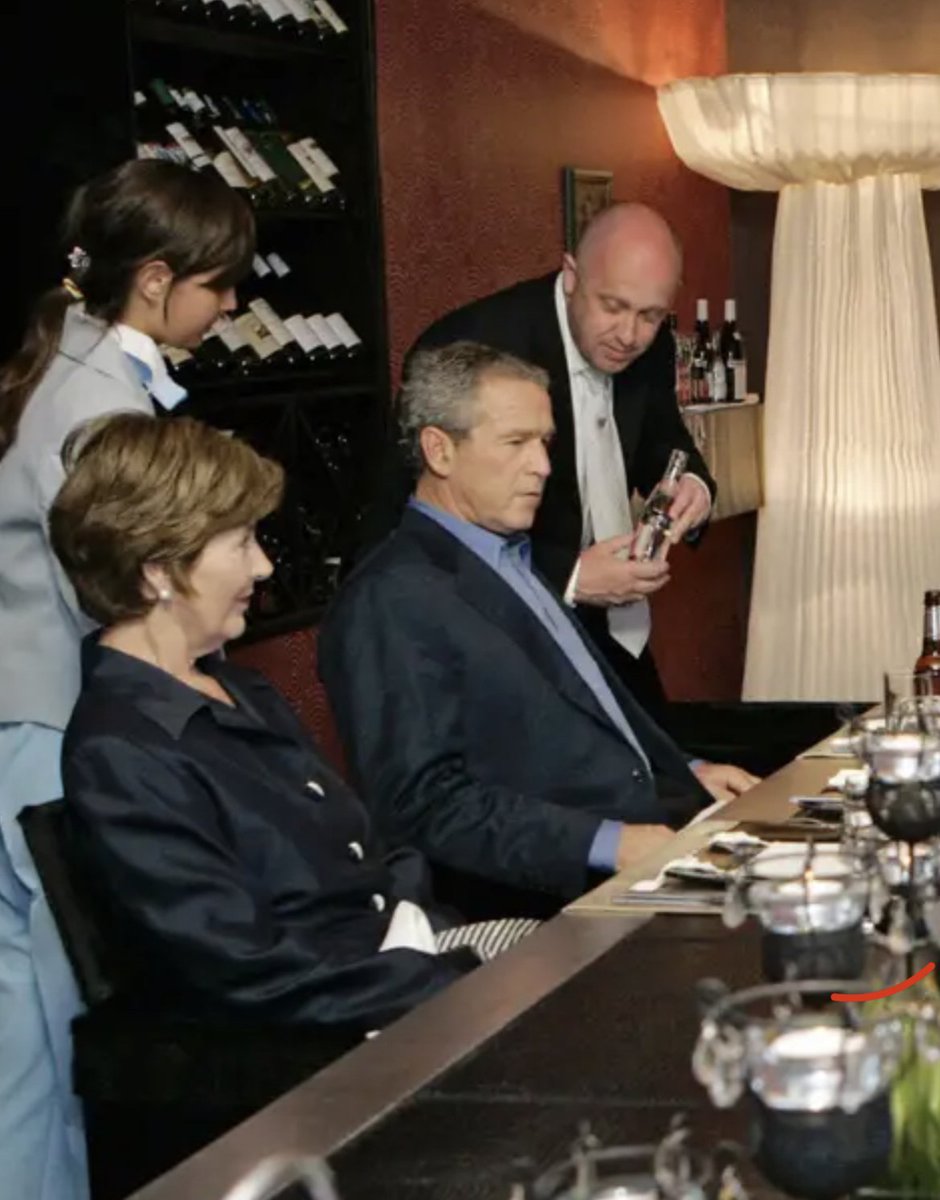 How times Change, Prigozhin offering U.S president George Bush a bottle of wine in 2006 during his visit to see Vladimir Putin