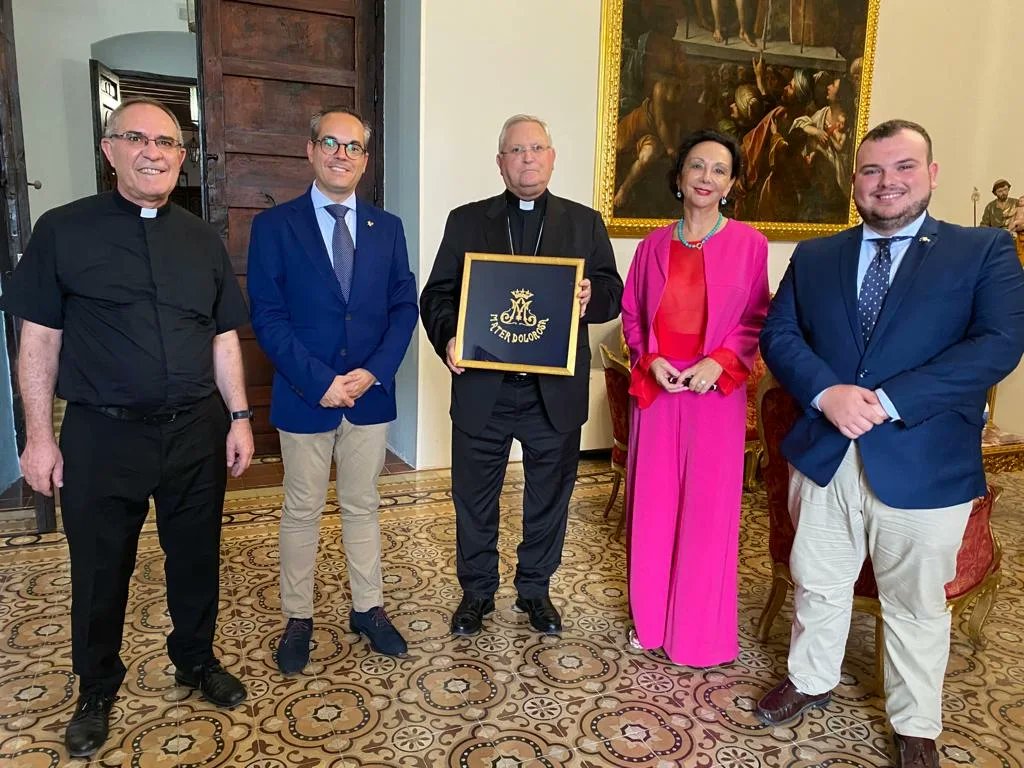 pasoazullorca's tweet photo. El presidente de la Hermandad de Labradores, Paso Azul y la camarera de la Stma. Virgen de los Dolores han sido recibidos por el Obispo de la Diócesis de Cartagena, Mons. José Manuel Lorca Planes, y le han entregado un anagrama de María realizado en nuestro taller de bordados https://t.co/LBjRBAFacx