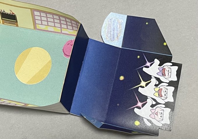 仕上げにカステラちゃん達を立ち上げます。水色ののりしろ(画像:色鉛筆で塗ったところです)に糊を付け、矢印の通りグラデーション部分の裏側に貼り付けます。ほぼ出来上がりです!いぬちゃんが「できた?」とでも言わんばかりに寄ってきました。 
