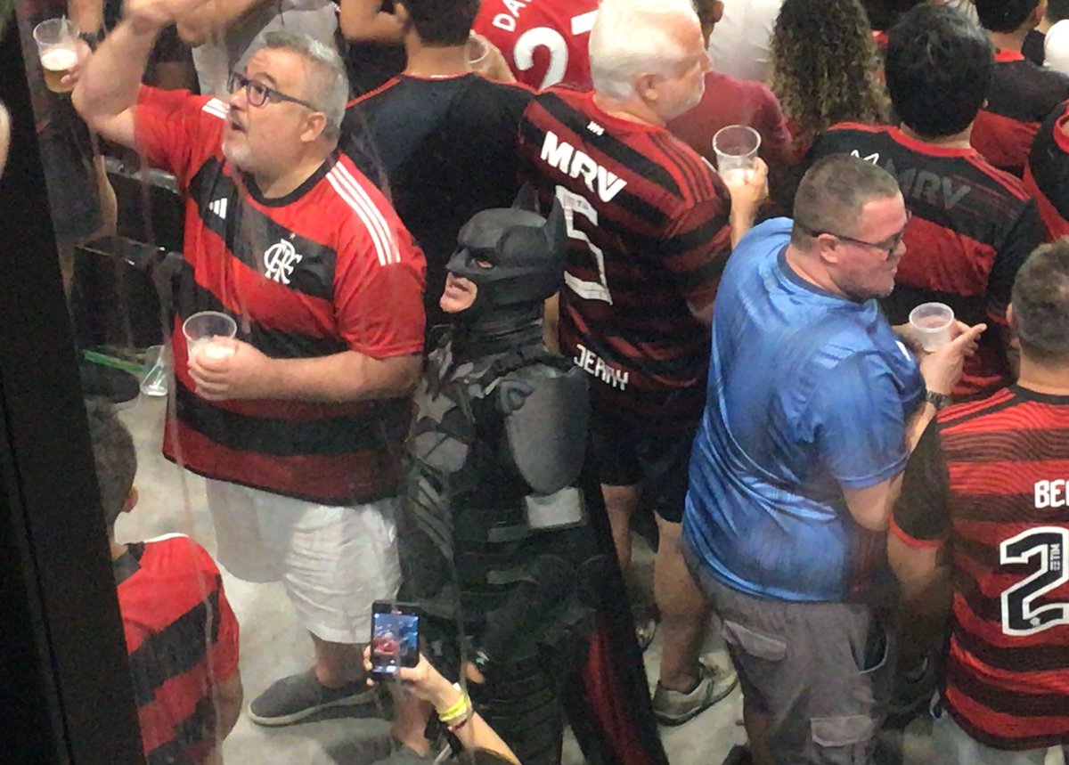 tiagotaam's tweet photo. Até o Batman Rubro-Negro está insatisfeito com o Flamengo. O sósia do super-herói está em frente ao local destinado aos dirigentes do clube fazendo cobranças. #trfla https://t.co/1n3FERLEot