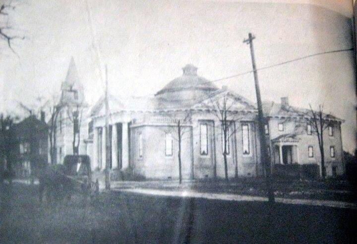 JMichaelBrewer's tweet photo. Since there has been some conversation this week about the cleanup work going on at the Old First Baptist Church in Jackson, GA, here is some historical information about the building that you might find interesting. 

The building was constructed on East Third Street, adjacent to its predecessor that was later torn down for the church parking lot on the east side of the building. The church building program, which was planned for several years, was led under the pastoral leadership of Dr. Robert Van Deventer, who pastored the First Baptist Church of Jackson for 16 years. The cornerstone was laid on May 22, 1914 and it was completed later that year at a cost of $35,000.00. The membership held their first service in the new building sanctuary on December 20th, 1914. The building is constructed primarily of brick and the original part of the building was 109 feet long by 60 feet wide, with a 35 foot wide loggia or portico supported by four massive columns. Other additions followed decades later. 

The materials used to build the church were sourced from Washington DC (brick), North Carolina (steel roof), Virginia (slate) and of course, Georgia (marble and lumber). The stain glass windows were crafted by the Empire Glass Company in Atlanta and dedicated as memorials to several founding members of the church. Most of the windows remain in place to this day. 

The style of this building is classical Grecian and featured porticos, pediments, doric columns, balustrade railings (removed in recent years) and pilasters. The defining feature of the Old First Baptist Church, which is unique in Butts County, is the monumental domed roof, which is constructed of curving copper panels and crowned with a windowed cupola to allow light to enter at the top. At some point, the dome was painted silver but as the paint has worn away, the oxidized green copper is beginning to show through again. 

At the time of its construction, the building contained basement spaces which held the kitchen, a dining hall, a gymnasium and a concrete swimming pool. The main floor consisted of the sanctuary, which could seat up to 400 people, with Sunday school rooms surrounding the sanctuary on the main level and upper floor which could be opened up when additional seating for worship services was needed. 

When it was completed in 1914, the church was very modern by the standards of the time, featuring electric lighting in all areas of the building (Jackson had only had electricity for a few years in 1914), and indoor plumbing throughout, both installed by the Newton-Carmichael Hardware Company of Jackson. It was heated by a modern furnace system built by the Williamson Heating Company of Atlanta and special care was taken in the design of the building to ensure excellent ventilation during the hotter months of the year. The sanctuary style is known as the Akron plan, which is known for having a central sanctuary surrounded by wedge shaped classrooms that radiated out from the pulpit area. 

The Old First Baptist Church was designed by Sayre & Baldwin Architects and contracted by Quartermus & McDonald Contractors of South Carolina. It was used by the congregation for just over 60 years, from December 20th, 1914 until the final service on July 20th, 1975. The congregation moved into a brand new church on Highway 16 west and the building was sold to the First Assembly of God, who would go on to use it for more than 20 years before it was sold again. As of August 2023, the building is privately owned and is for sale, though no plans have been announced for it as of this writing. 

The black and white photo was made at the time the building was completed and shows both the older original wooden structure next door that was torn down in 1916, two years after the 1914 building was completed. The colorized post card also is from 1914 and shows the copper dome as it would have looked before it weathered green. #ButtsCountyGa #History #JacksonGA #architecture