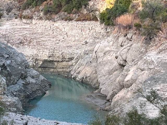 makdrou's tweet photo. Ο δράκος του νερού (update)

Ο υδατοφράκτης του Σαϊττά στέγνωσε. Η φωτογραφία είναι πρόσφατη. Αυτή είναι η μόνη υδατοδεξαμενή στο δάσος Τροόδους, προσβάσιμη στα πυροσβεστικά ελικόπτερα.

Από τον Μάιο έγινε εκτροπή του ποταμού και το νερό μεταφέρεται με αγωγούς σε ένα ιχθυοτροφείο που χτίστηκε και λειτουργεί παράνομα στην κοίτη του Κούρη και σε κρατική γη που καταπατήθηκε.

Τώρα που στέγνωσε ο ποταμός, το ιχθυοτροφείο αντλεί ασταμάτητα από διατρήσεις που άνοιξε στην όχθη του υδατοφράκτη.

Το παράνομο ιχθυοτροφείο έχει καταπιεί έναν ποταμό νερό και τώρα στραγγίζει τα υπόγεια αποθέματα.

Σε μια χώρα που πριν κάποια χρόνια μετέφερε νερό με δεξαμενόπλοια για να μη διψάσει και να μη βρωμίσει.

Εν μέσω ξηρασίας και κλιματικής αλλαγής.

Και το κράτος θεατής…
