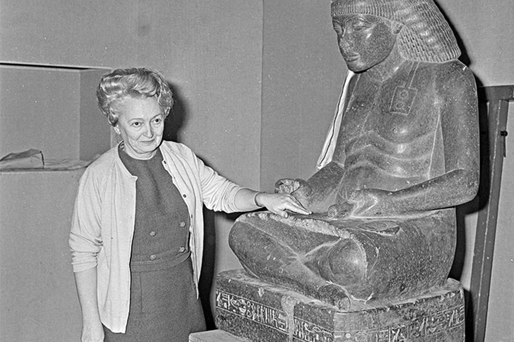 💛 this c. 1976 photo of French Egyptologist Christiane Desroches Noblecourt & the 3350 year old scribal statue of the high official Amenhotep son of Hapu. 

She's indicating how the inscriptions on his lap were worn away by generations of ancient temple visitors 

#StatueSunday