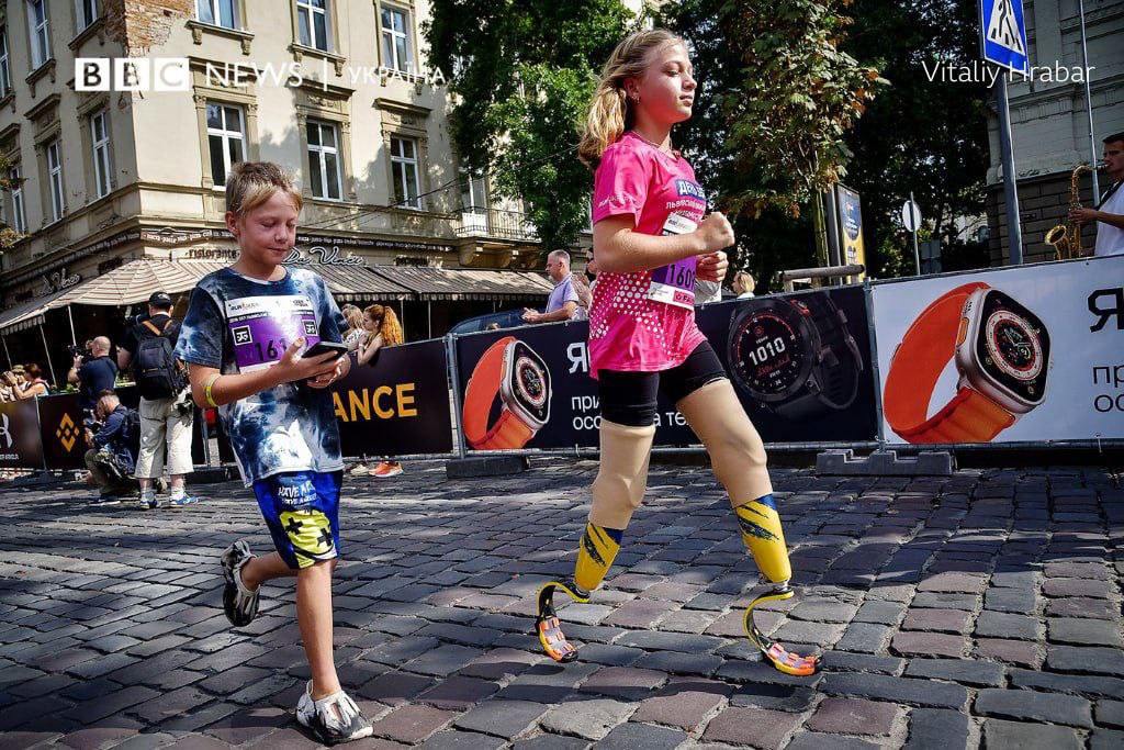 Heute, während des Lviv Invincibility 2023 Halbmarathons, legen die 11-jährige Yana und ihr Bruder Yaroslav die Strecke mutig zurück. Yanas Widerstandskraft leuchtet hell auf; sie verlor ihre Beine durch einen russischen Raketenangriff auf den Bahnhof von Kramatorsk im Jahr 2022