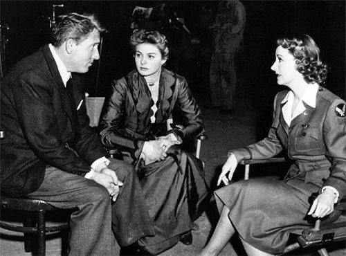 ingrid bergman, still dressed up in her ‘gaslight (1944)’ costume, visiting irene dunne and spencer tracy on the set of ‘a guy named joe’, 1943