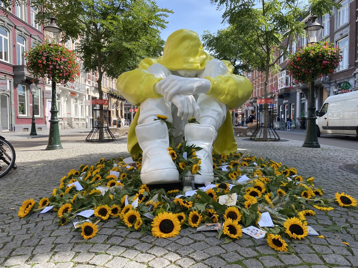 Aan de voeten, en zelfs in de laarzen van de tiener in gele jas liggen zonnebloemen, voorzien van kaartjes. "Zonnebloemen zijn bloemen van hoop.  Ze richten hun kopjes naar boven, naar de zon" linkedin.com/feed/update/ur…
