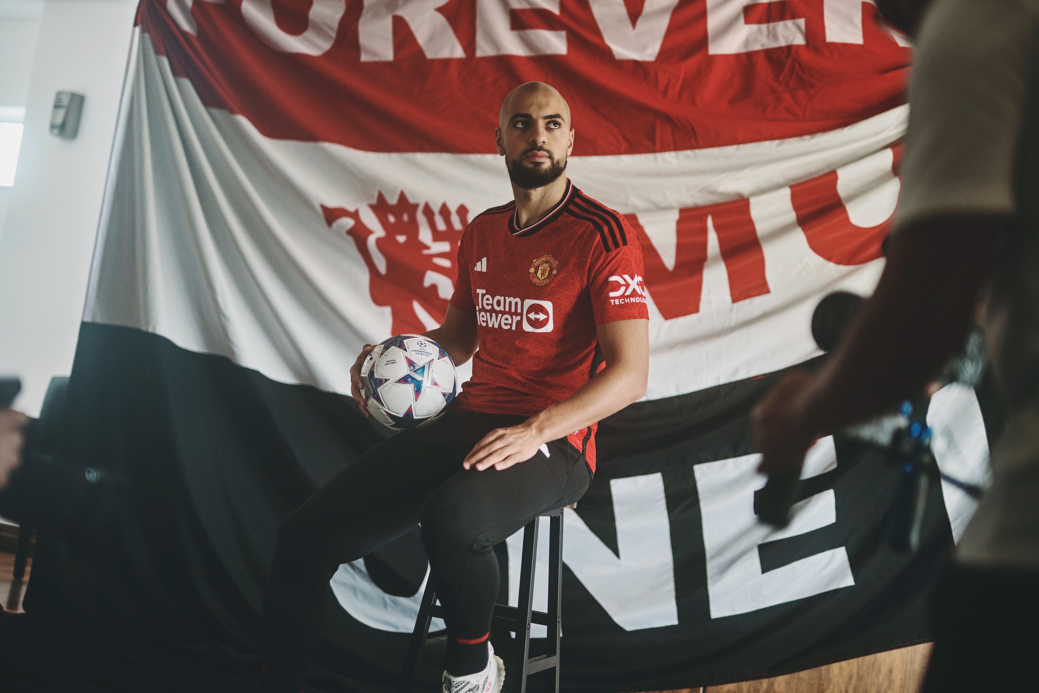 Sofyan Amrabat poses in a United home shirt.