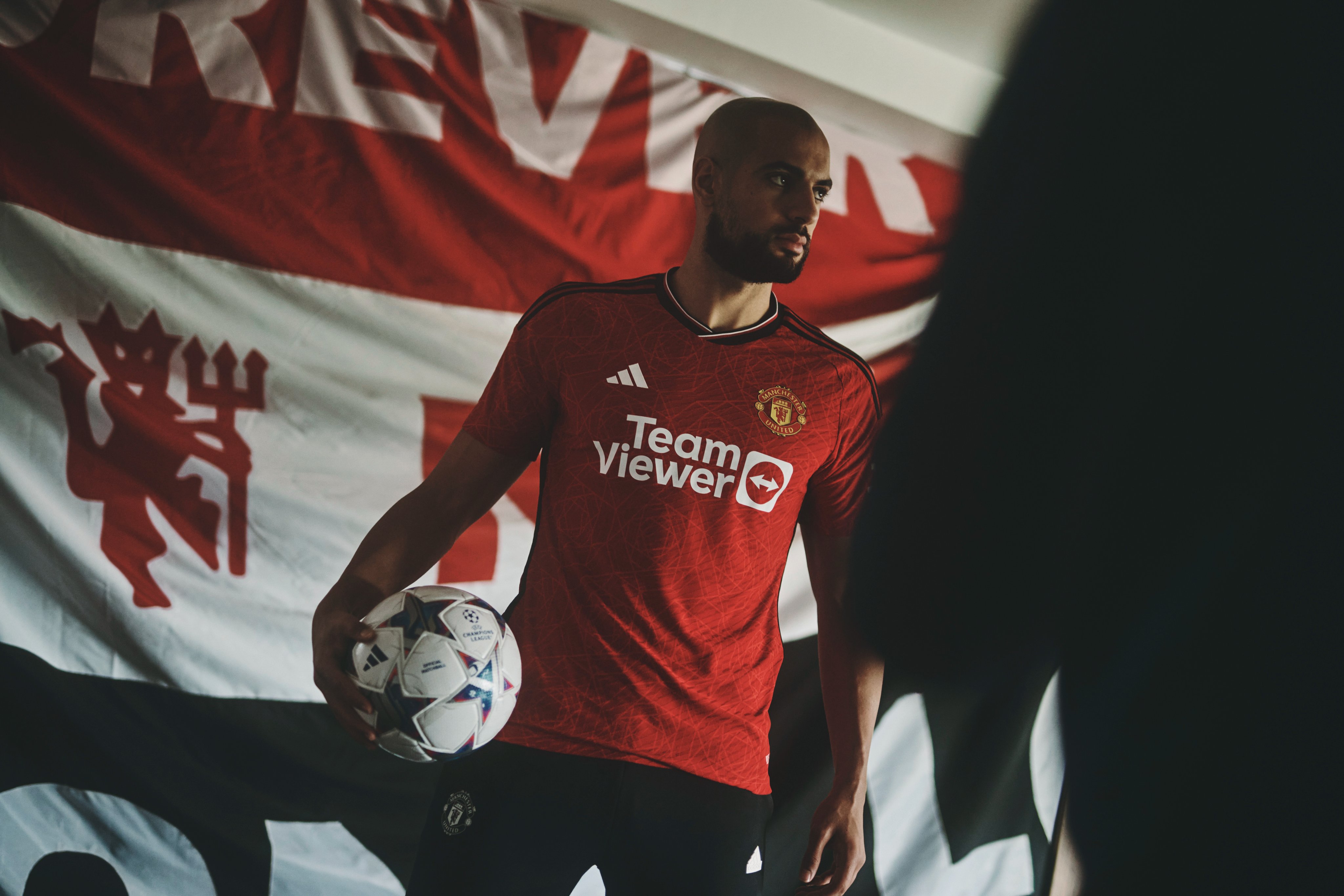 Sofyan Amrabat poses in a United home shirt.