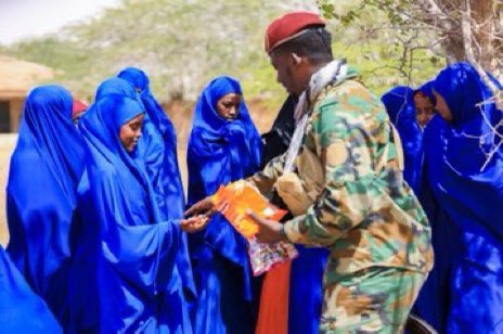 SONNALIVE's tweet photo. School children in Harardhere town of Galmudug State receive snacks from the National Armed Forces officers as they resume their education and normal life after being liberated from the Al-shabab terrorists who ruled them brutally for 15 years. #GalmudugState #Harardhere #Alshabab