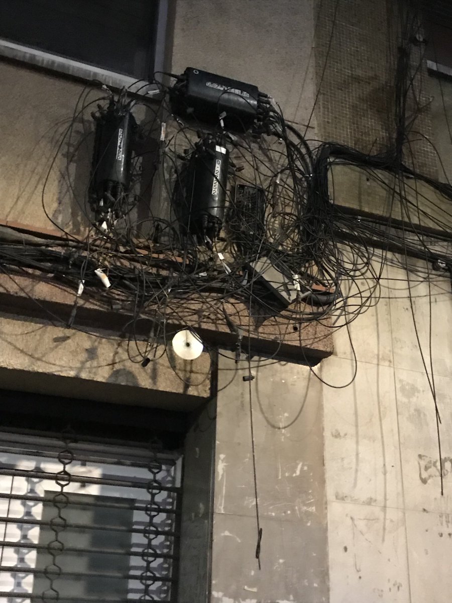 joan_catlliure's tweet photo. De veritat a l’Ajuntament BCN, o a la Gene, no els importa q la façana d’un edifici mostri aquest manyoc de cables de fibra òptica i les seves caixes de derivacions, tant i tant absolutament anti estètic i matusser? Hi hauria d’haver una normativa q ho reguli i eviti. Siusplau. https://t.co/Roq9TODaGn
