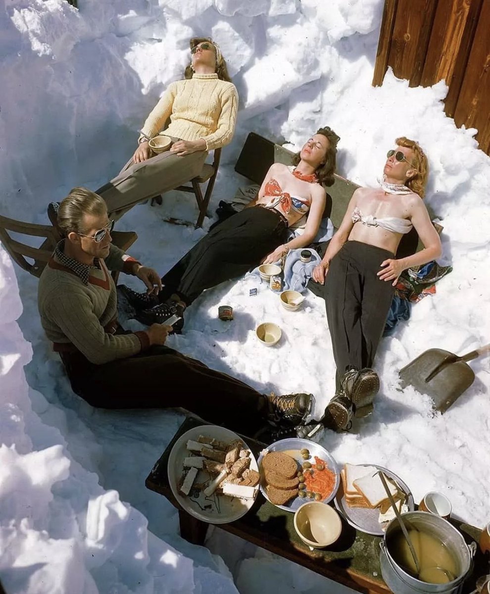historyinmemes's tweet photo. Four skiers sunbathe in the snow in Sun Valley, Idaho, 1946. Next to them is a spread of sliced white bread, olives, lox, and some sort of soup. Photo by George Silk.

My initial thought of the photo was that it looked very European, and I was very surprised that this was in Idaho. I did a little bit of digging and discovered that Sun Valley has quite the history. Ernest Hemingway finished his book, "For Whom the Bell Tolls," while staying at the resort in 1939. Celebrities like Clark Gable, Gary Cooper, Errol Flynn, Lucille Ball, Marilyn Monroe, and several members of the Kennedy family were all frequent visitors.

During World War 2, the Sun Valley resort was closed in 1942 and was used as a hospital for the U.S. Navy. The resort was reopened to the public in December 1946, which was when this photo was taken.