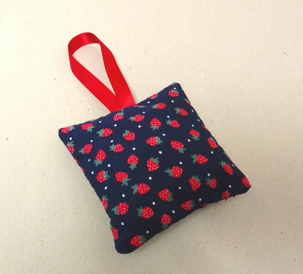 A single lavender bag in navy with small red strawberries and a matching red hanging ribbon. Handmade in Cornwall. #lavender #lavenderbag #lavendersachet #smallbiz #giftforher #newonfolksy folksy.com/items/8198915-…