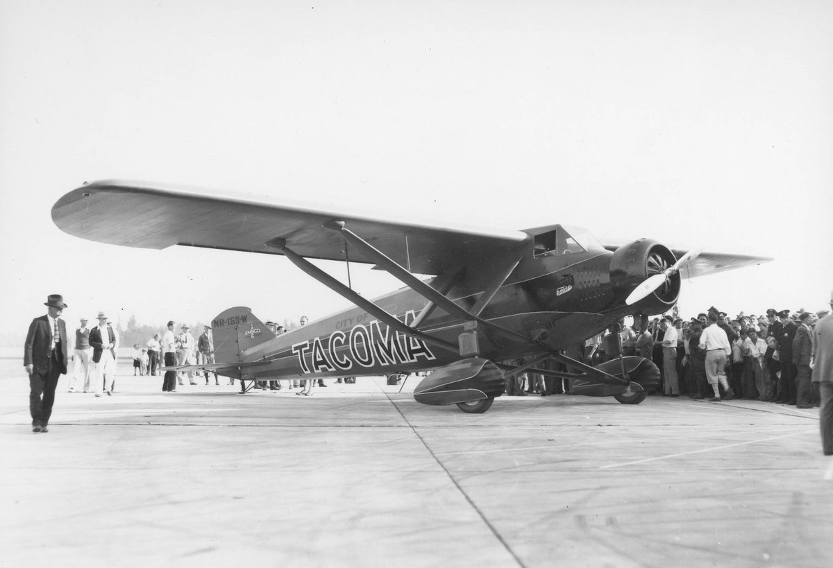 Harold Bromley's fourth airplane, the 'City of Tacoma,' preparing for his Tokyo to Tacoma flight. The red Emsco single engine monoplane roared off on September 14, 1930 from a 6,800 foot strip of hard packed sand at Sabishiro Beach, 350 miles north of Tokyo.