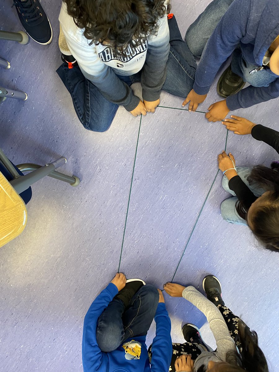 We are building a math community by learning to talk about our ideas, listen to others, work together, and ask questions. Today, students worked in groups to make different shapes using a piece of yarn. Everyone had to be touching the yarn at all times. Awesome teamwork, 1A!
