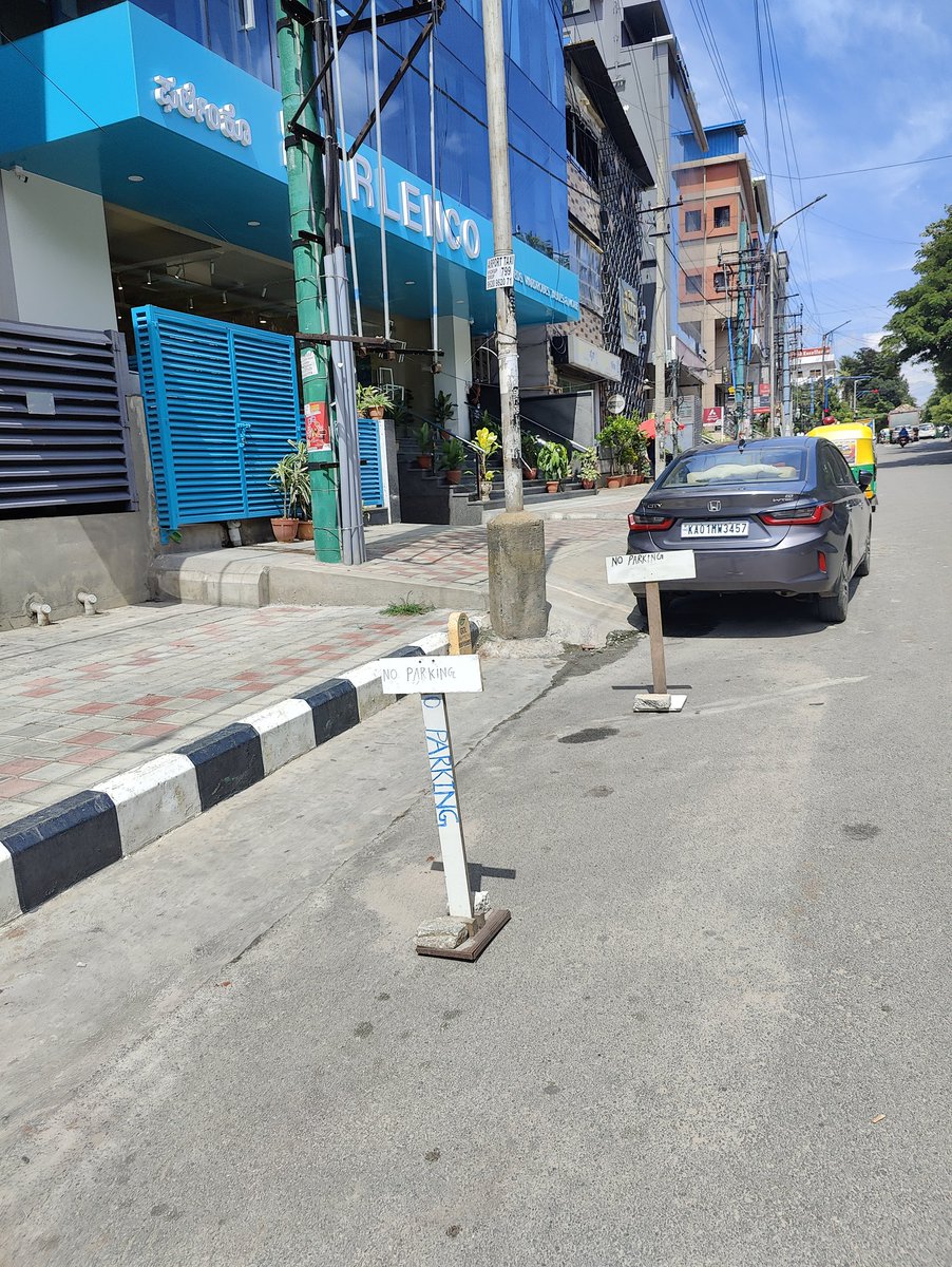 adarshnair89's tweet photo. @BlrCityPolice I just want to know how can private company stake claim on a public road. Can public roads be converted to private parking. When asked the security guy is threatening me. What kind of hooliganisam is this, please look into it and help us . https://t.co/iE89T1WYx6